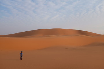 Fototapeta na wymiar A young man alone on a vast desert landscape showing isolation concept