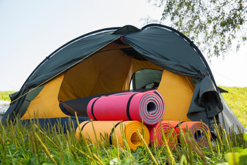 Open tent and rolled sleeping pads.