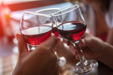 Happy friends having fun outdoors, toasting red wine. Focus on glasses