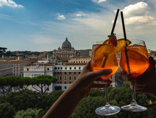 Travel photo concept. A couple is holding glasses of Aperol in the bar inside the Castle...