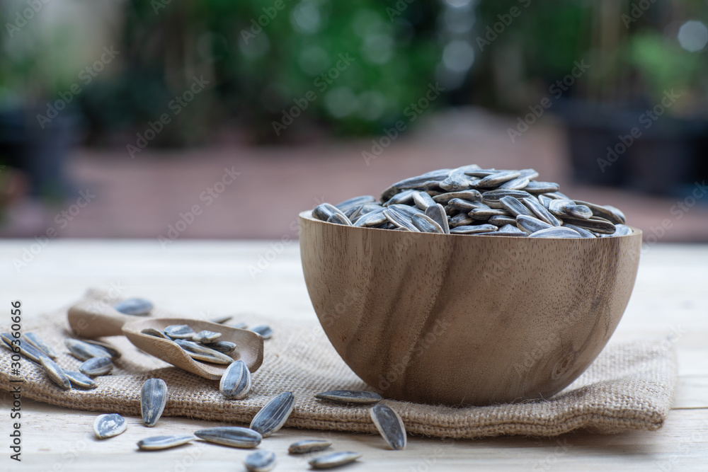 Wall mural Sunflower seed, snack, in wooden bowl on wood table