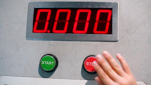 Closeup of hands on start and stop buttons.