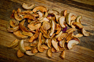 Dried sliced apples, healthy, closeup shot on a wooden surface.