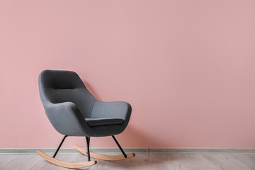 Soft rocking chair near color wall