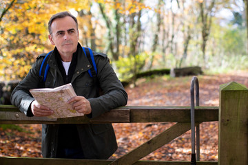 Active Mature Man With Map Walking Through Autumn Woodland In Slow Motion