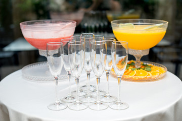 A pyramid of glasses. Orange and pink Champagne with fruits.