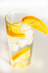 Glass of cold fresh water with slices of ice and lemon.