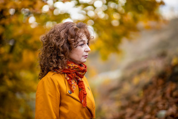 Seasonal portrait of a mature woman outdoor in vibrant forest