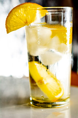 Glass of cold fresh water with slices of ice and lemon.