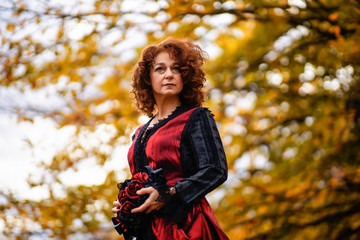 Fototapeta na wymiar Portrait of a mature lady in a vintage dress, autumn time.