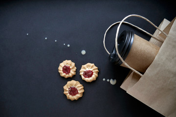 Coffee to go concept. Paper cup with cookies on dark background. Cafe breakfast 