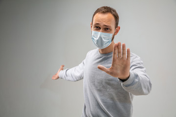 Stop it. Caucasian man wearing the respiratory protection mask against air pollution and dust particles exceed the safety limits. Healthcare, environmental, ecology concept. Allergy, headache.