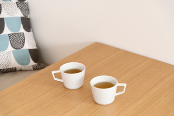 無垢材のテーブルと2つのカップ　紅茶　２人　二人　ふたり　マグ　お茶　休憩　木製テーブル　木目　机　デスク　余白　文字スペース　コピースペース　ホワイトスペース