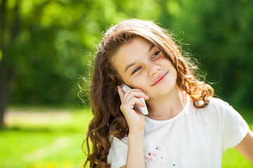 Portrait of a beautiful young little girl calling by phone