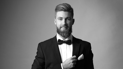 Portrait of elegant man with beard in black classic suit.