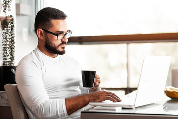 Focused man working on his laptop at home