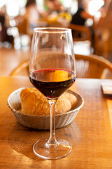One glass ruby red wine served in cafe during dinner with many people