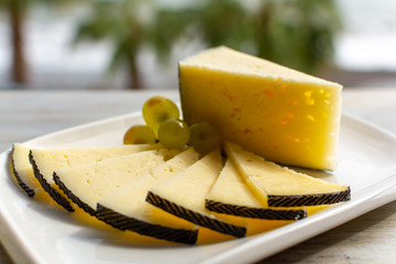 Spanish sheep cheese served with white grapes outside with sea view