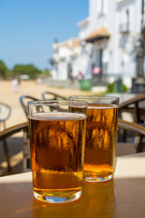 Cold amber color light spanish beer served in glass in outdoor cafe in town on sand, El Rocio in Andalusia, Spain