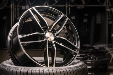 Fotobehang new expensive cast aluminum disc wheel black color, photographed on the tire. dark background, close-up. © Vladimir Razgulyaev