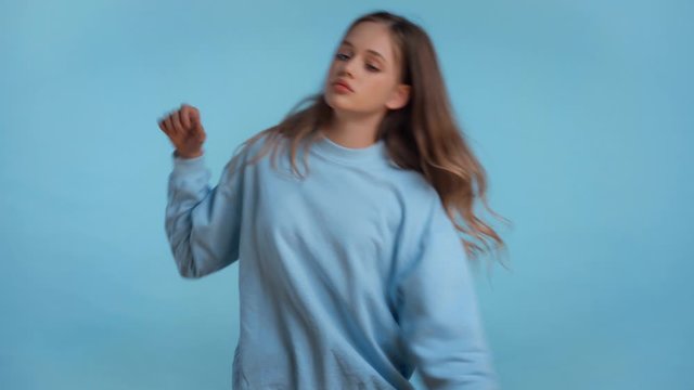 teenager dancing and smiling isolated on blue
