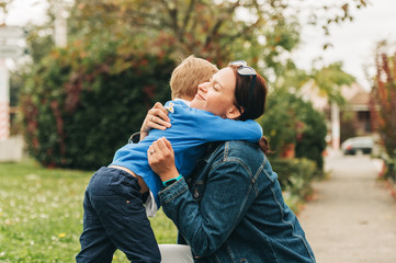 Little boy offering flowers to his lovely mom, happy parenthood