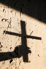 Shadow of the hand holding a cross