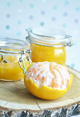yellow jar of honey with peeled tangerine