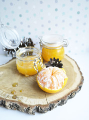 yellow jar of honey with peeled tangerine