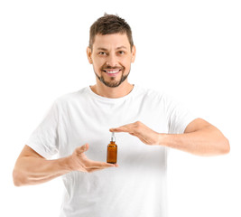 Handsome man with cosmetic product on white background