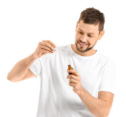 Handsome man with cosmetic product on white background