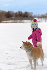 雪遊びをする女の子と柴犬