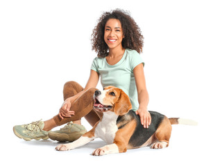 Beautiful African-American woman with cute dog on white background