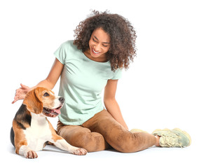 Beautiful African-American woman with cute dog on white background