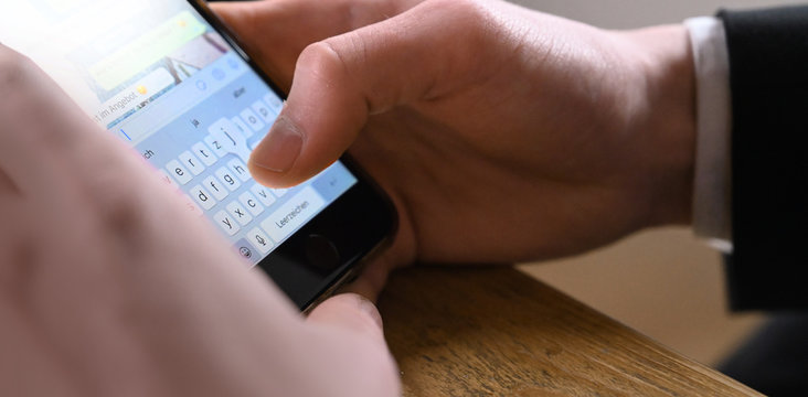 Businessman schreibt eine Nachricht und tippt eine Kommunikation via Chat mit dem Handy cellphone im B&uuml;ro.