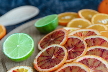 Cut into round slices of multi-colored citrus fruits, orange, lime, bloody orange. Deep blue and...