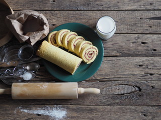 Fototapeta na wymiar pastry roll on a green plate with ingredients on a brown background