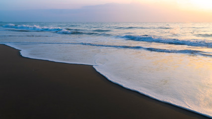Morning ocean waves on the black sandy beach