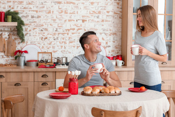 Happy young couple having breakfast on Christmas eve