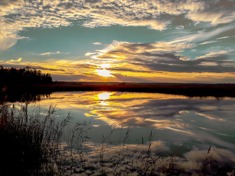 Lake In Sunset With Light Blue Cloudy Sky Reflection