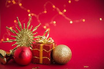 christmas composition with red and golden balls, red background with lights bokeh