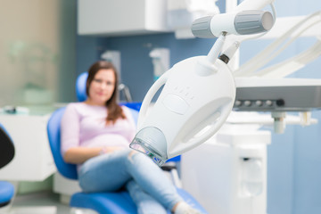 Teeth whitening device in a dental clinic, photo on the background of a woman sitting in a dental chair