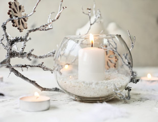 Glowing candles with Christmas decor on white background