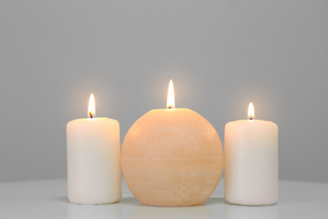 Obraz na płótnie Canvas Glowing candles on white table