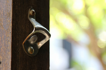 Old classic bottle opener on wooden pole.