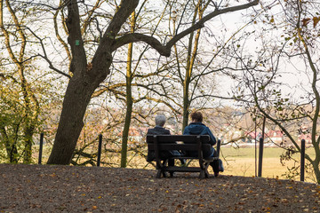 staruszkowie siedzący na ławce, jesień © Tomasz