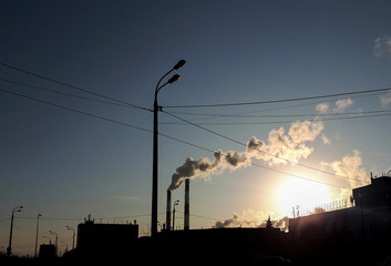 smoke from the chimney in the city in the evening