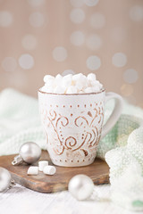 Mug with coffee and marshmallow, sweater, cinnamon. Cozy christmas composition. Hygge concept Soft focus