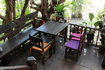 Old wooden restaurant set with table and chair on the wooden terrace.