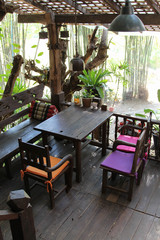 Old wooden restaurant set with table and chair on the wooden terrace.